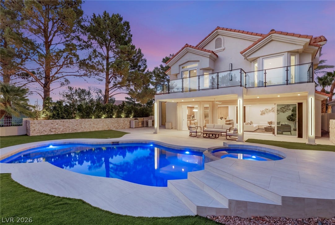 An inviting backyard oasis offers a sparkling blue pool, an integrated spa, and an upper-level balcony for elevated outdoor enjoyment.