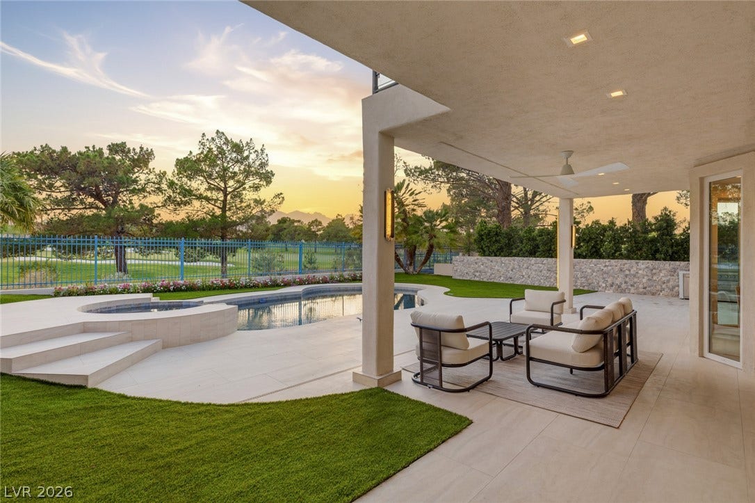 An inviting covered patio adjoins a sparkling pool and spa, offering picturesque views of the golf course.