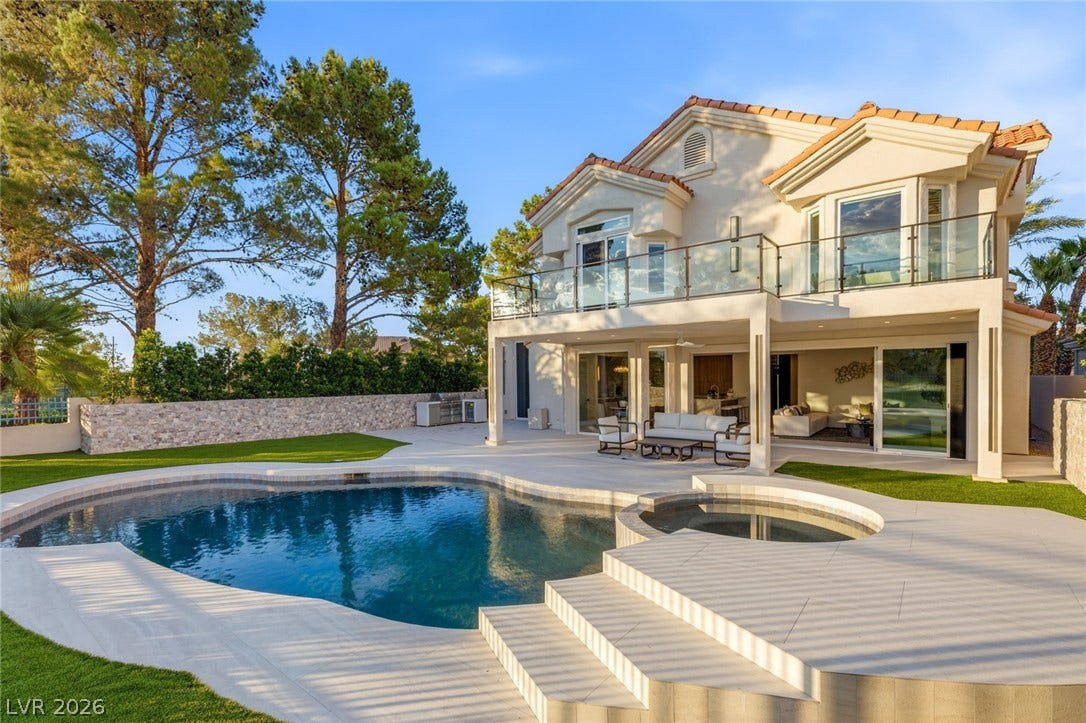 A private backyard oasis features a shimmering pool and spa alongside a spacious patio, perfect for outdoor entertaining.