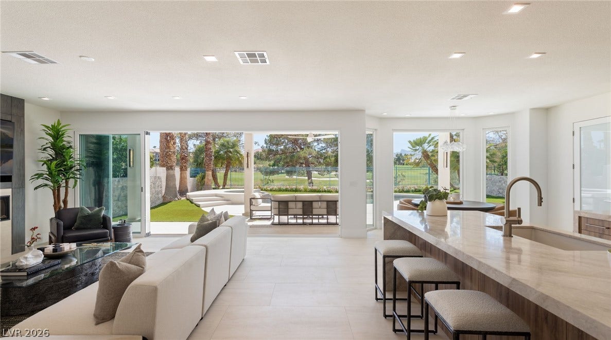 Seamless indoor-outdoor living with a golf course view, connecting the elegant living area and gourmet kitchen.