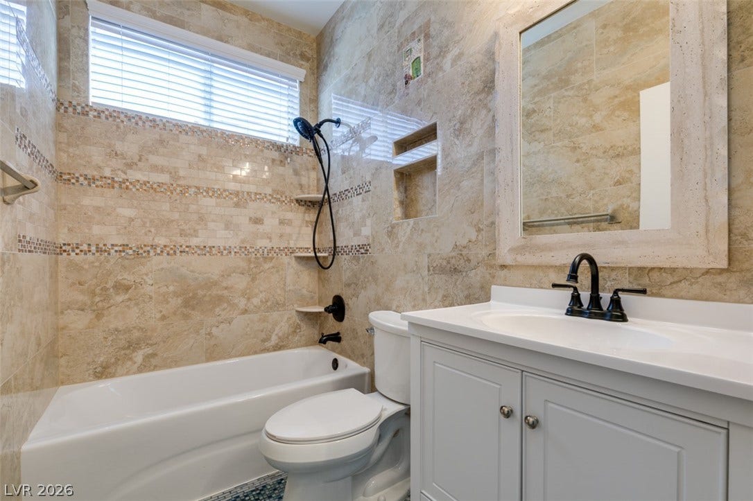 10513 Shanna Trellis Avenue, Las Vegas, NV 89144 Full bathroom featuring vanity, tile walls, and bathing tub / shower combination