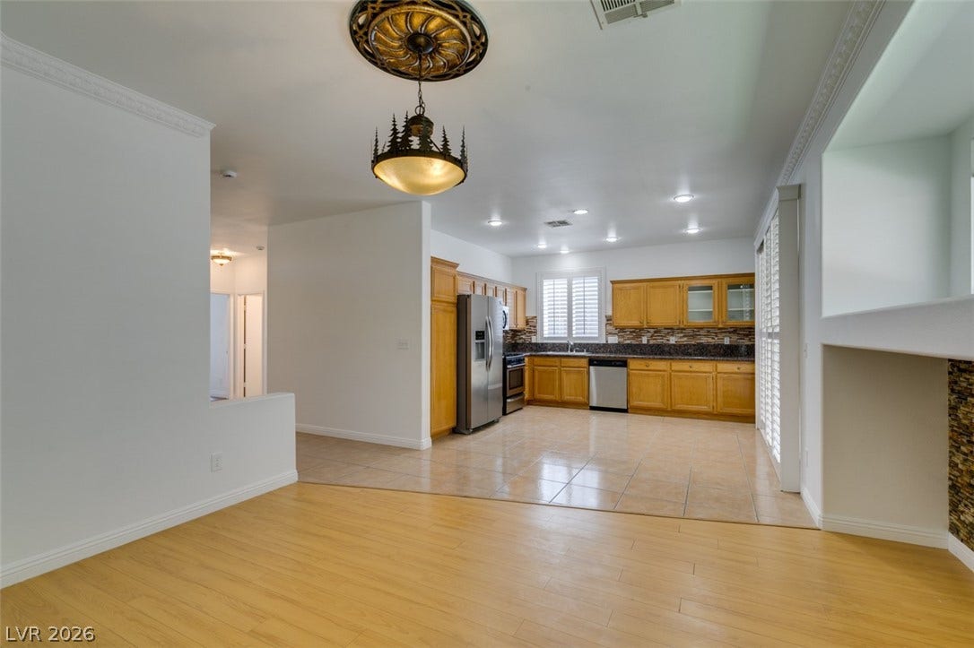 10513 Shanna Trellis Avenue, Las Vegas, NV 89144 Kitchen with dark countertops, light wood-style flooring, appliances with stainless steel finishes, glass insert cabinets, and tasteful backsplash