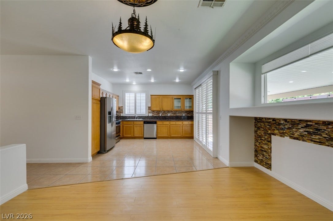 10513 Shanna Trellis Avenue, Las Vegas, NV 89144 Kitchen featuring dark countertops, appliances with stainless steel finishes, light tile patterned floors, tasteful backsplash, and glass insert cabinets