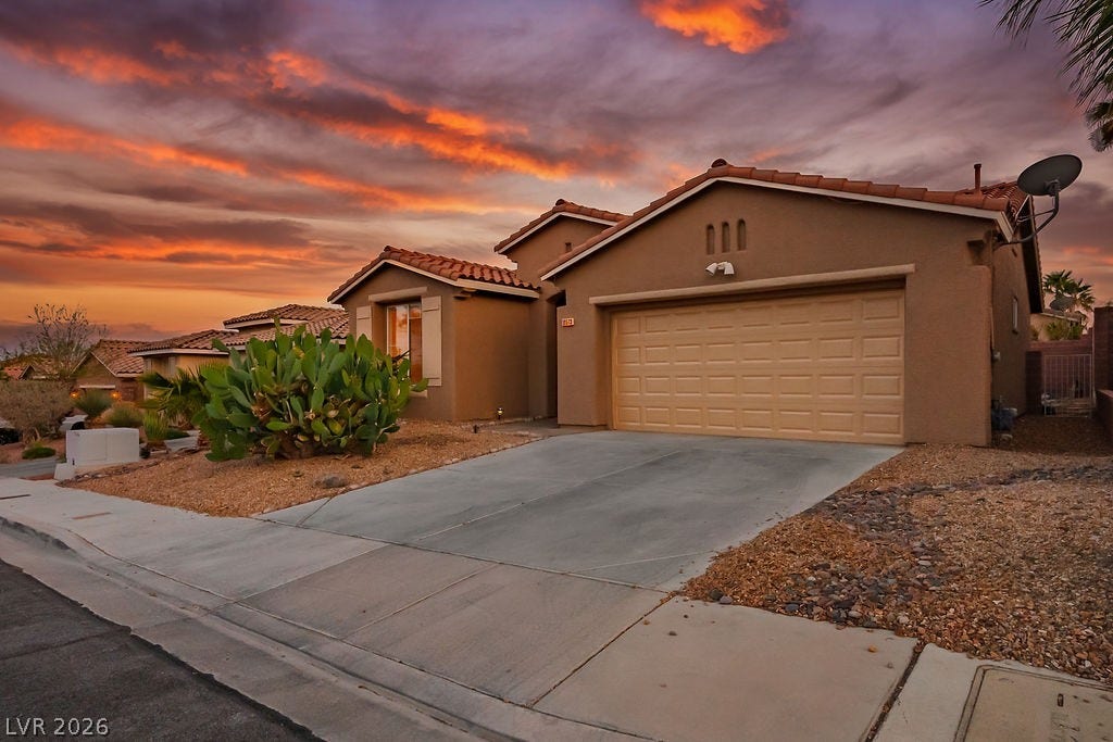 10513 Shanna Trellis Avenue, Las Vegas, NV 89144 Mediterranean / spanish house with stucco siding, an attached garage, concrete driveway, and a tiled roof
