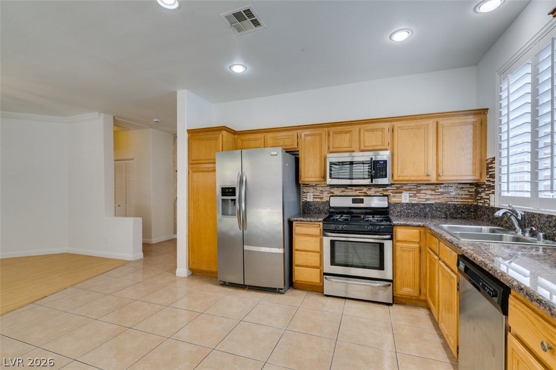 10513 Shanna Trellis Avenue, Las Vegas, NV 89144 Kitchen featuring appliances with stainless steel finishes, backsplash, light tile patterned floors, recessed lighting, and dark stone counters