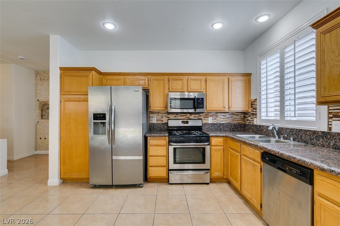 10513 Shanna Trellis Avenue, Las Vegas, NV 89144 Kitchen featuring appliances with stainless steel finishes, dark countertops, light tile patterned flooring, backsplash, and recessed lighting