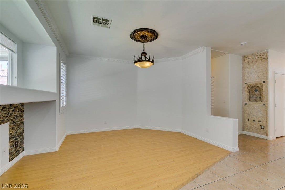10513 Shanna Trellis Avenue, Las Vegas, NV 89144 Unfurnished dining area featuring light wood-style flooring, ornamental molding, and a fireplace