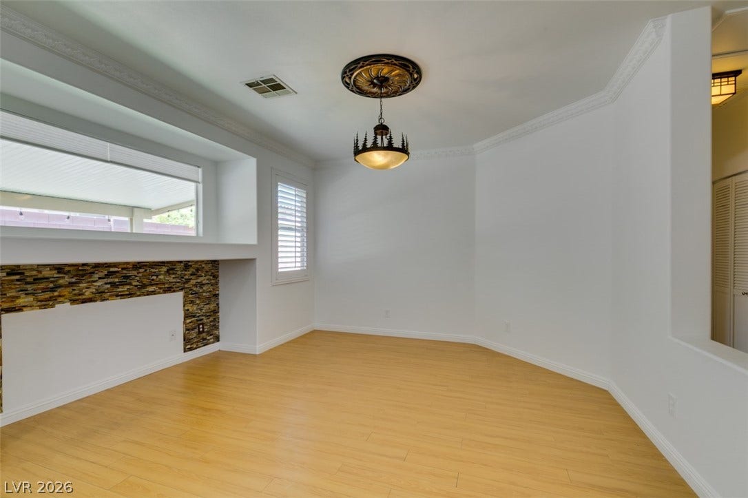 10513 Shanna Trellis Avenue, Las Vegas, NV 89144 Unfurnished living room with light wood-style floors and crown molding