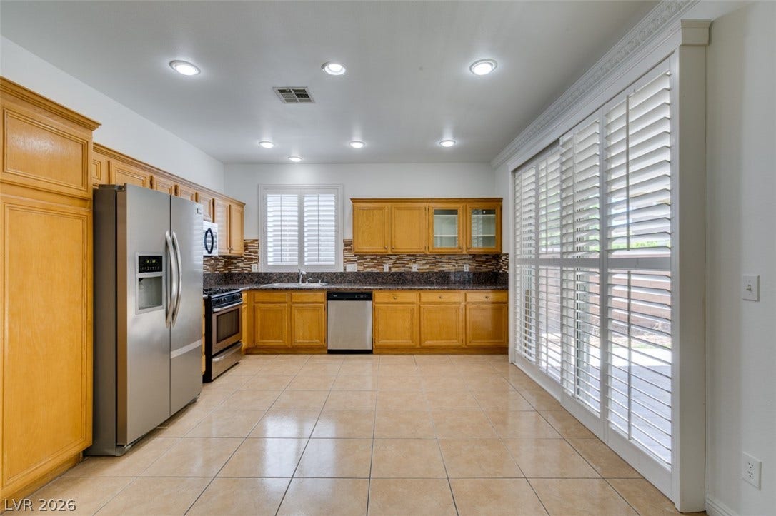 10513 Shanna Trellis Avenue, Las Vegas, NV 89144 Kitchen with tasteful backsplash, appliances with stainless steel finishes, light tile patterned floors, glass insert cabinets, and recessed lighting