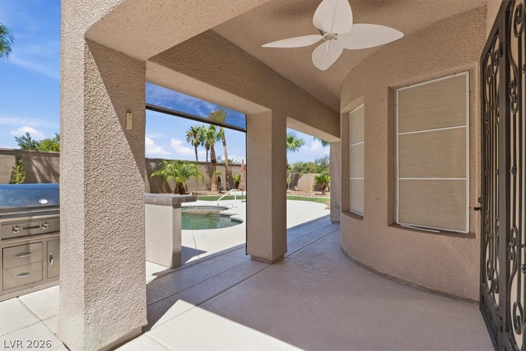 Shaded concrete columns frame a covered back porch overlooking the private pool area.