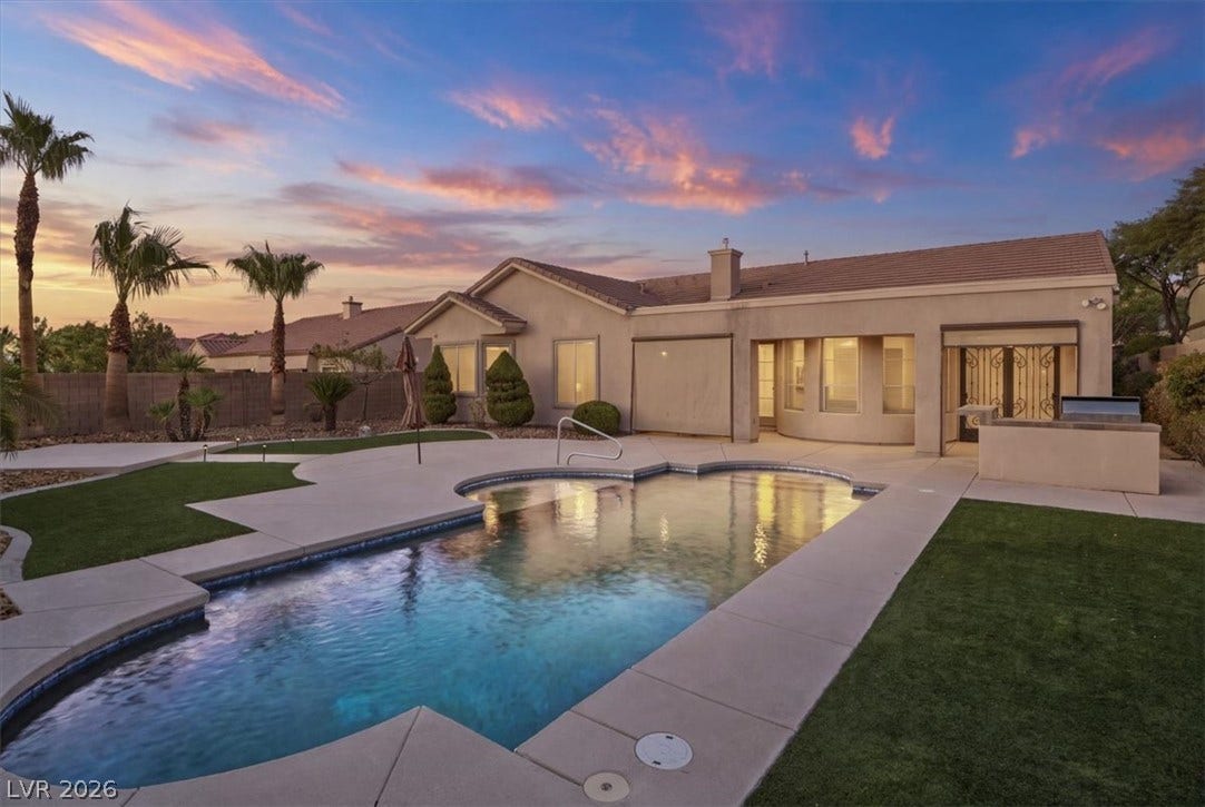 An inviting backyard oasis centers around a sparkling swimming pool framed by manicured turf.