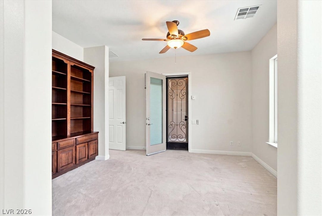 Plush carpet flooring pairs with a classic built-in bookcase in this versatile workspace.