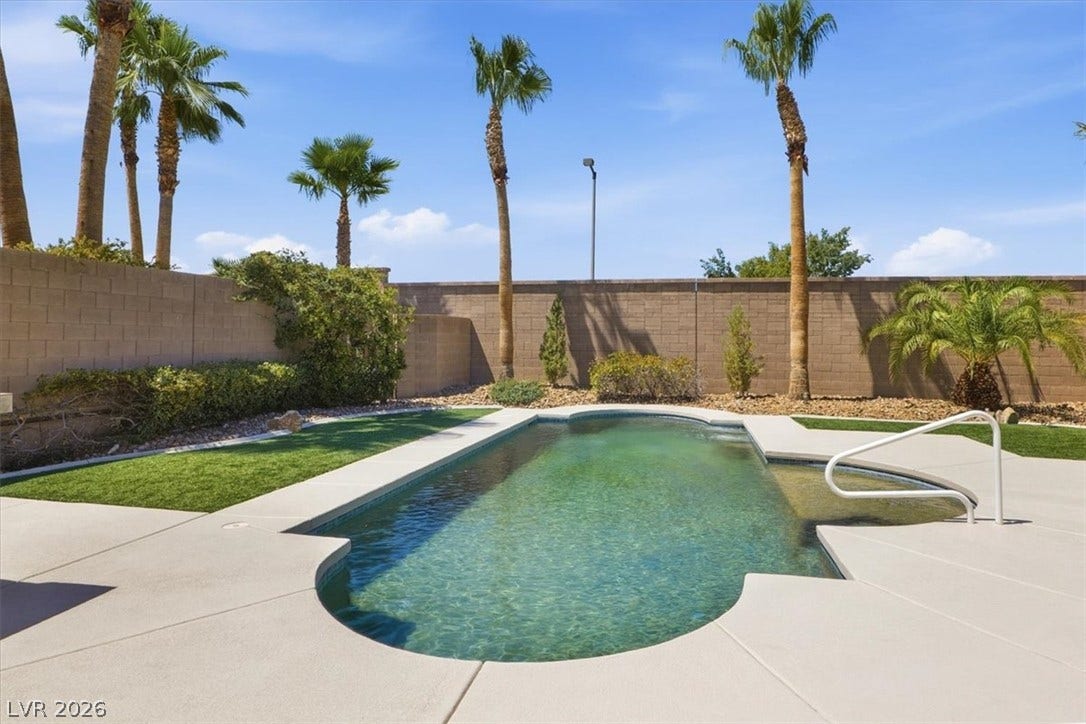 Palm trees sway gently behind a sparkling private pool surrounded by clean concrete decking.