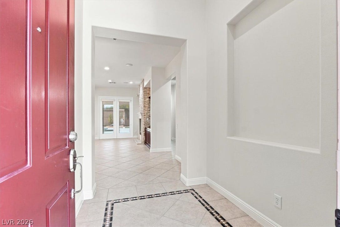Tiled flooring and a recessed wall niche welcome visitors inside the front entryway.