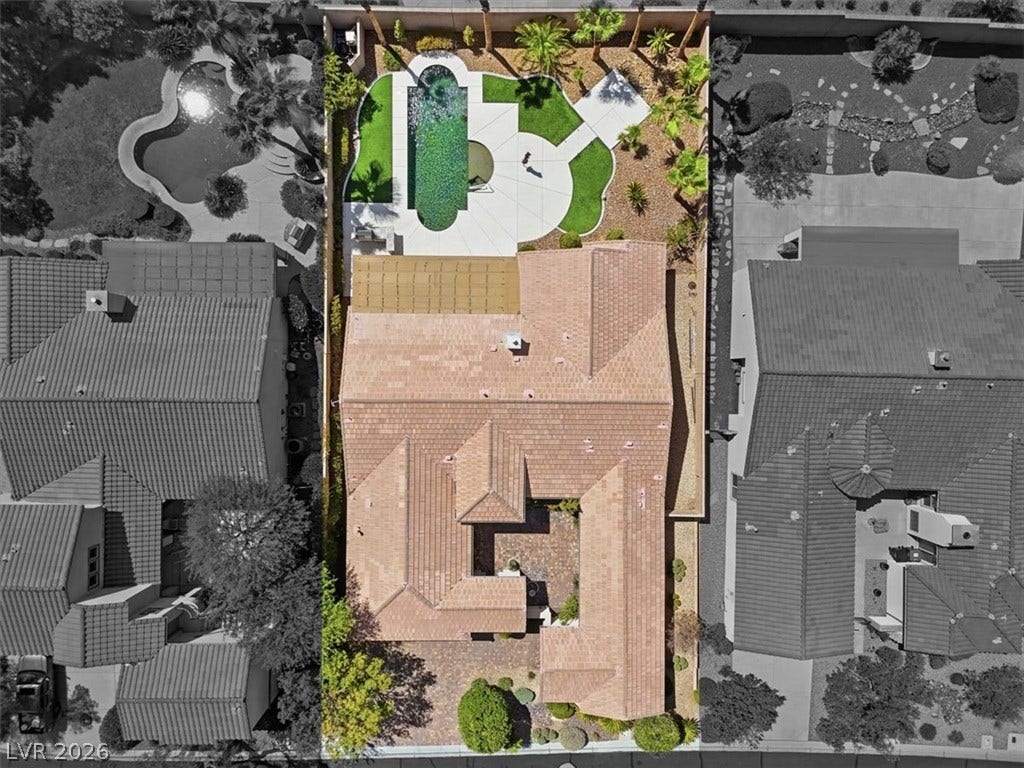 An aerial perspective showcases the tiled rooflines, central courtyard, and backyard pool of the home.