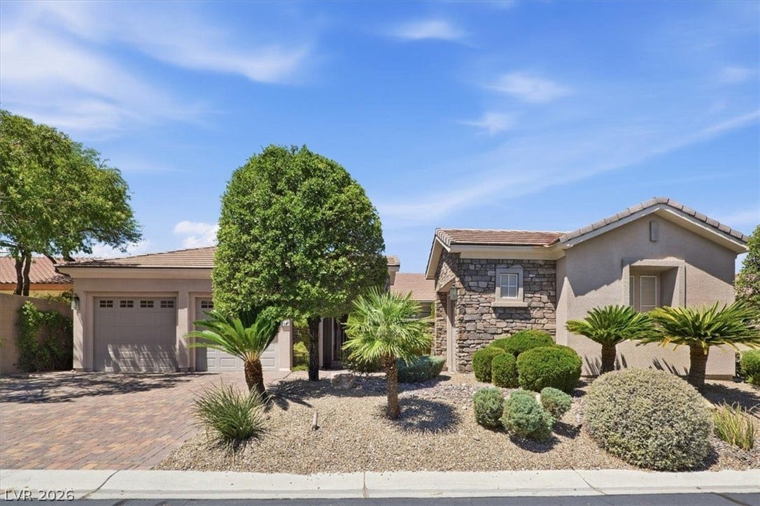 Stone accents and desert landscaping create a welcoming entrance to this single-level home.