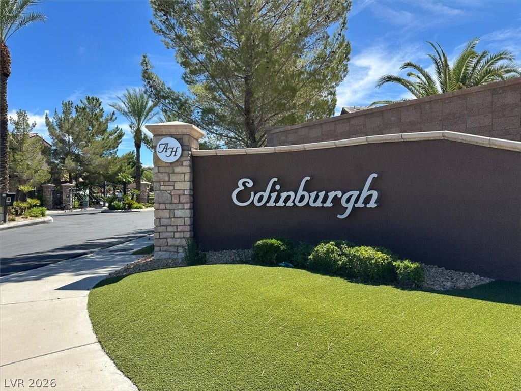 Manicured green lawn and professional masonry line the gated entrance of this neighborhood.
