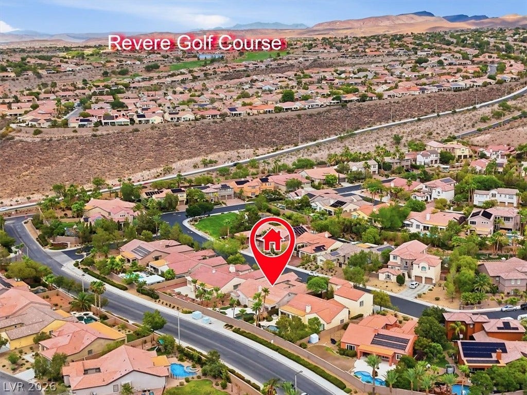 Aerial view highlights the home set against a desert mountain landscape and nearby golf course.