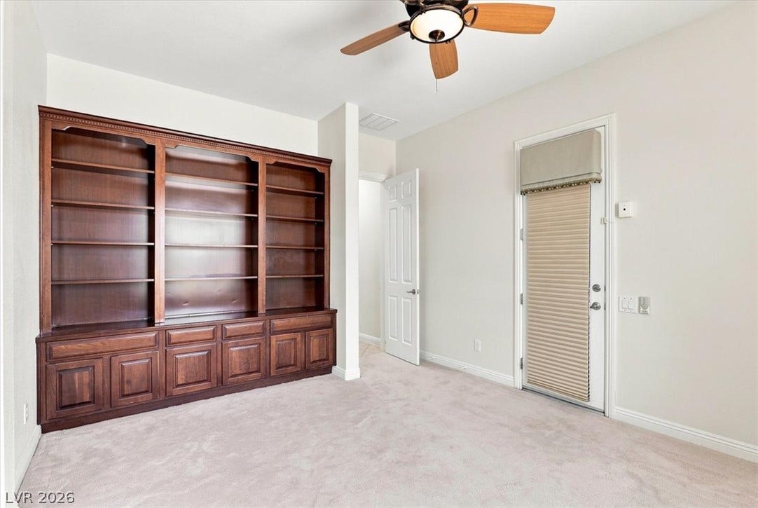 Rich wood built-ins and plush carpeting highlight this versatile space.