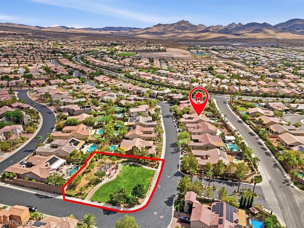 An aerial perspective showcases the neighborhood layout nestled against a desert mountain backdrop.