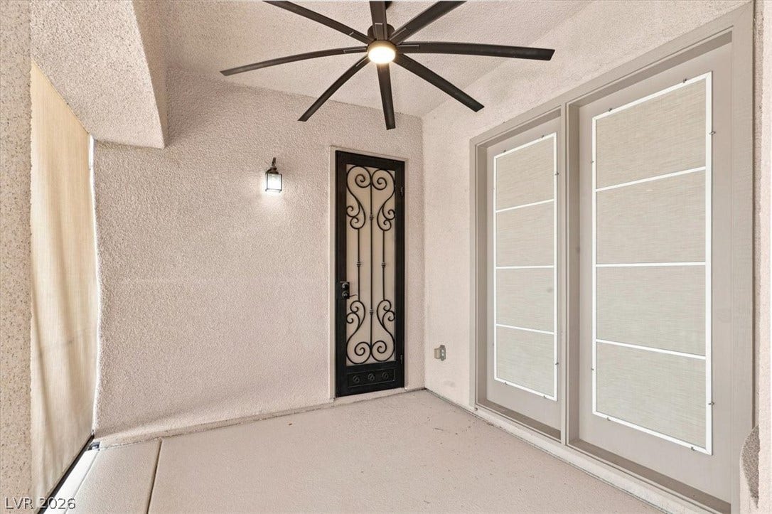 A sheltered concrete entryway welcomes guests with a decorative wrought iron security door.