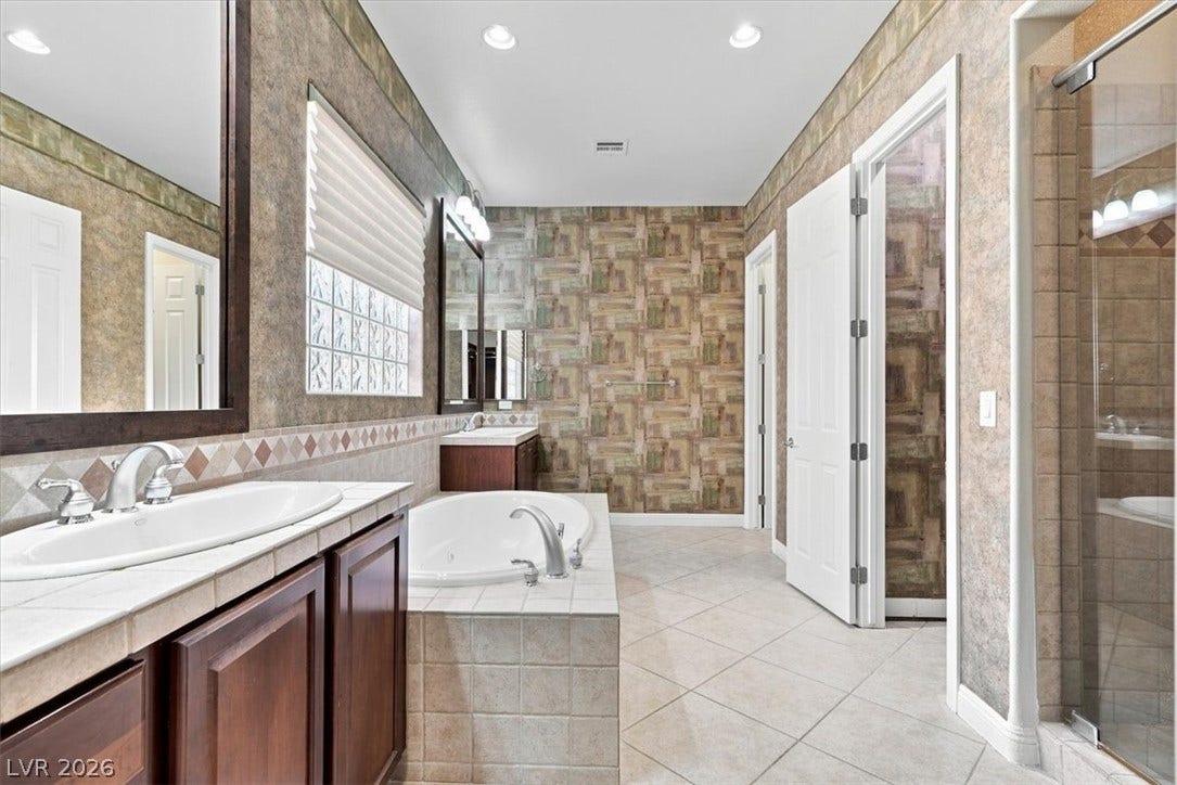 Tiled flooring and a built-in soaking tub define this main bathroom space.