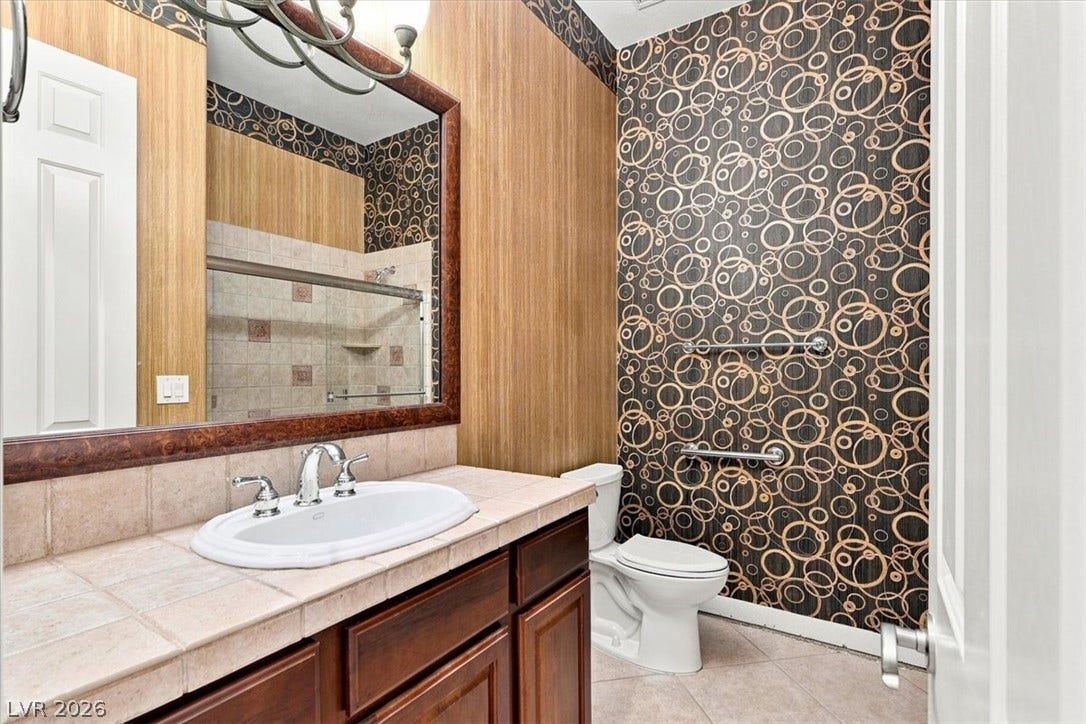 Tiled countertops and distinctive wall finishes define this well-appointed bathroom space.