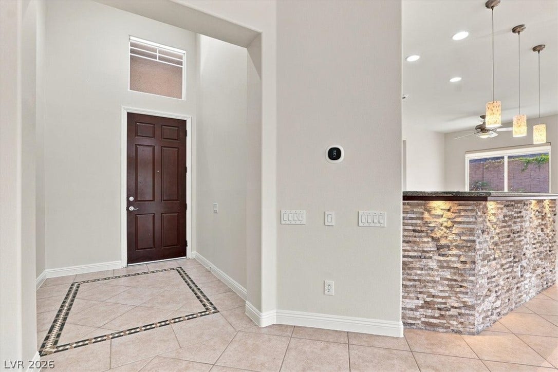 High ceilings and inlaid tile flooring welcome guests at the entryway.