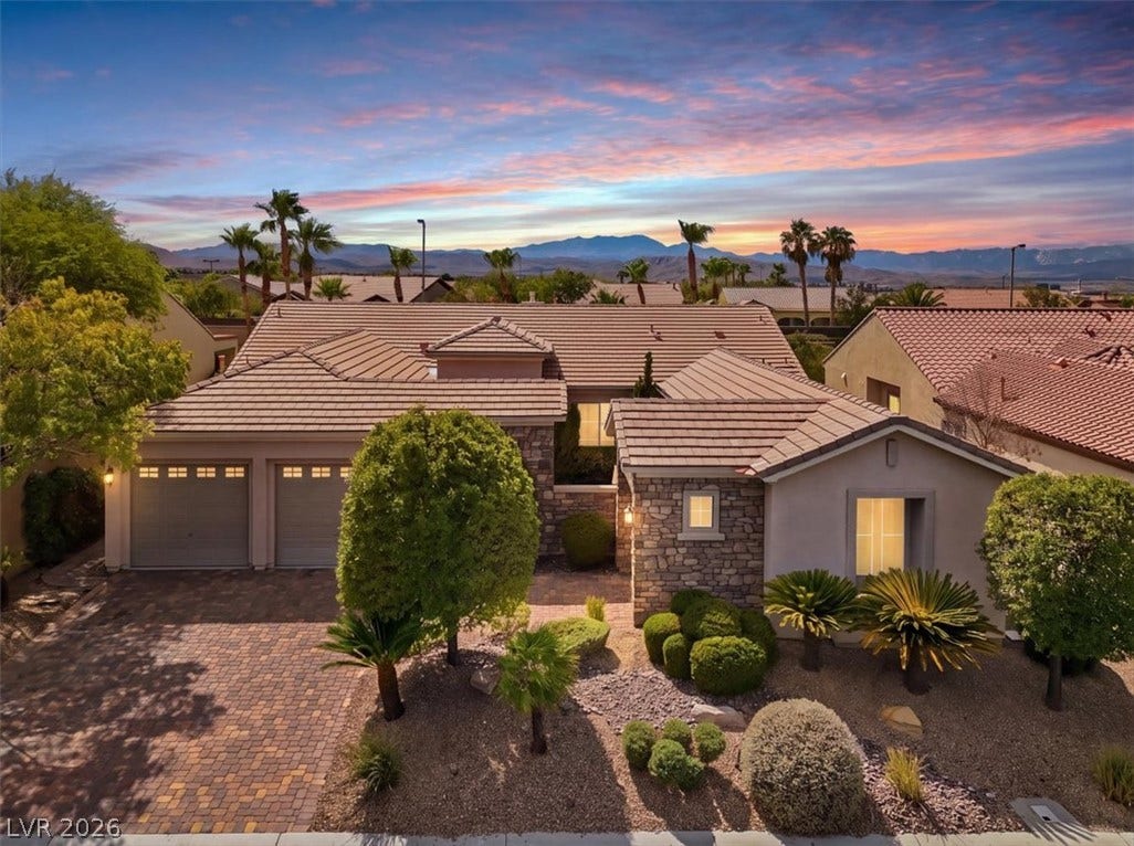 Desert landscaping and stone accents frame this low-profile residence set against a mountain backdrop.