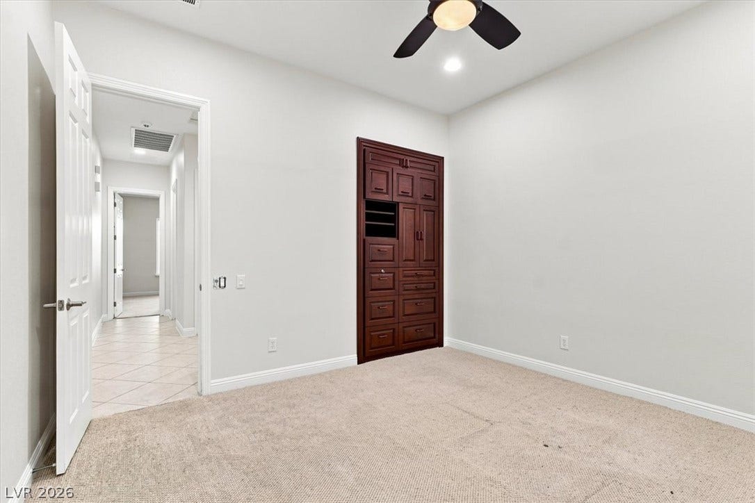 Plush carpeting and a built-in wooden cabinet define this versatile interior space.