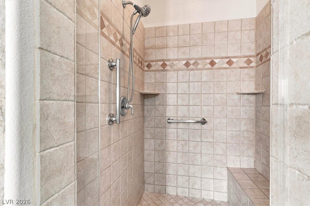 Tiled walls and a built-in bench highlight this walk-in shower.