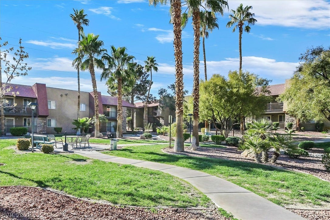 5081 River Glen Drive, #97, Las Vegas, NV 89103 A winding concrete pathway navigates through manicured greenspace and towering palm trees.