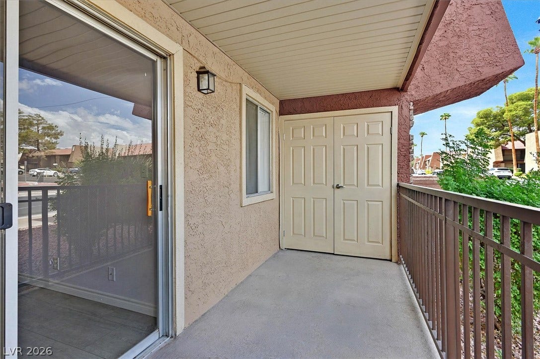 5081 River Glen Drive, #97, Las Vegas, NV 89103 A private covered balcony features durable concrete flooring and textured stucco walls.