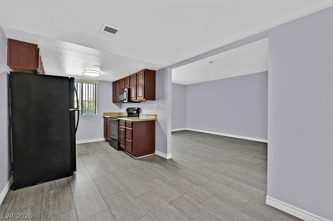 5081 River Glen Drive, #97, Las Vegas, NV 89103 An opening connects the kitchen to a spacious living area.