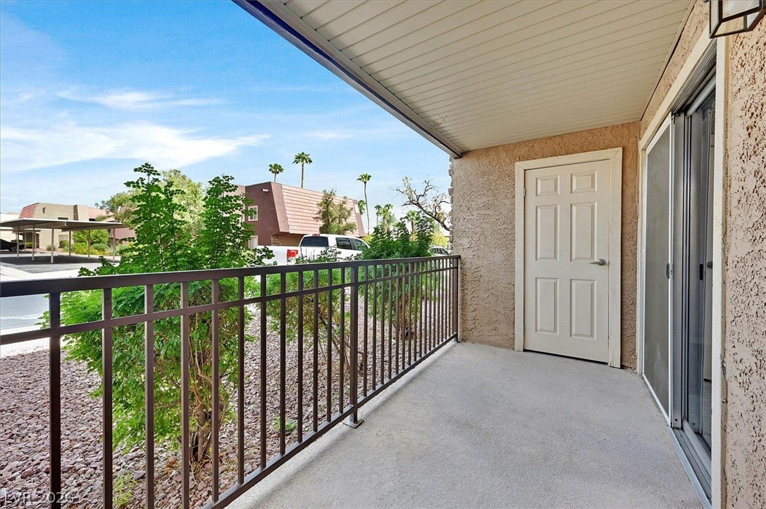 5081 River Glen Drive, #97, Las Vegas, NV 89103 Sheltered outdoor space features a concrete surface, metal railings, and sliding glass doors.