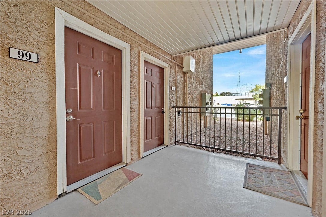 5081 River Glen Drive, #97, Las Vegas, NV 89103 A covered concrete entryway features secure metal railings and textured stucco walls.