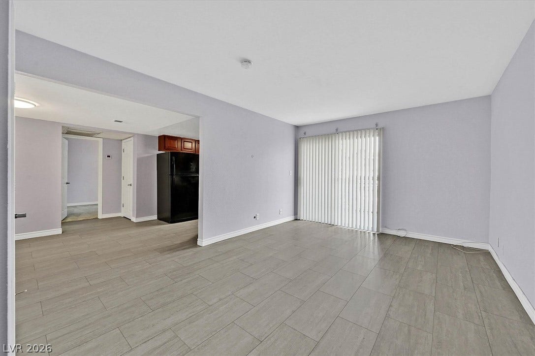 5081 River Glen Drive, #97, Las Vegas, NV 89103 Vinyl Plank flooring and sliding glass doors define this open living area.