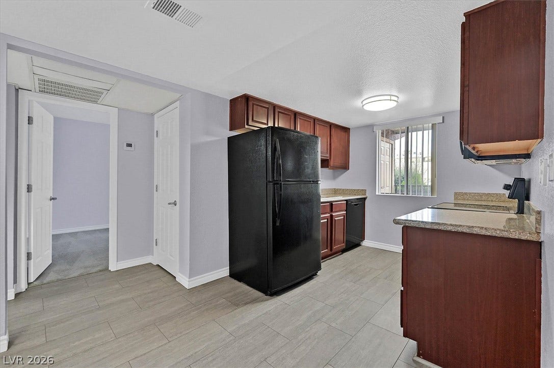 5081 River Glen Drive, #97, Las Vegas, NV 89103 Rich wood cabinetry contrasts beautifully with durable Vinyl flooring in this functional culinary space.