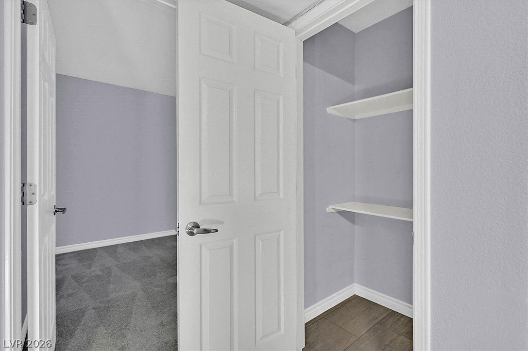 5081 River Glen Drive, #97, Las Vegas, NV 89103 A convenient storage closet with built-in shelving stands adjacent to a carpeted bedroom.