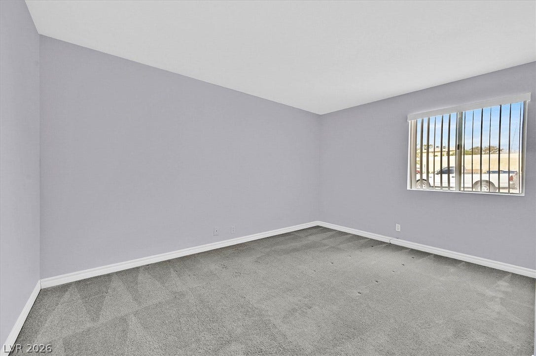 5081 River Glen Drive, #97, Las Vegas, NV 89103 Plush carpeting and a wide window define the primary bedroom.