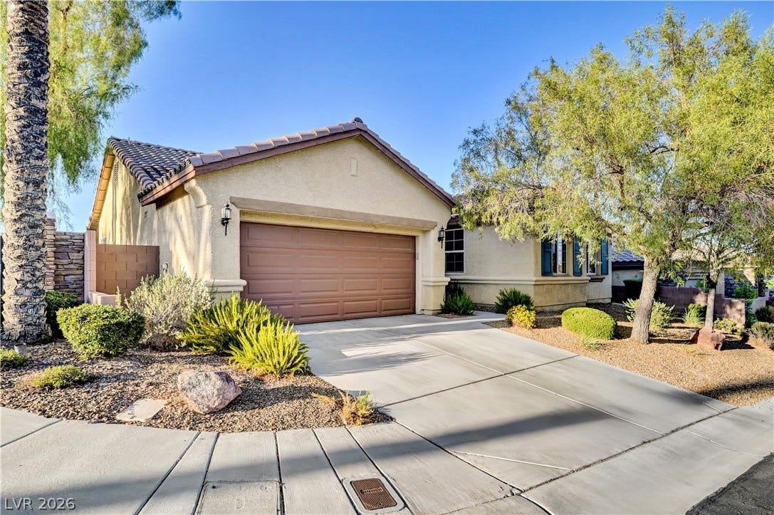 9928 Tradition Creek Avenue, Las Vegas, NV 89149 A well-maintained stucco home offers a two-car garage and mature landscaping.