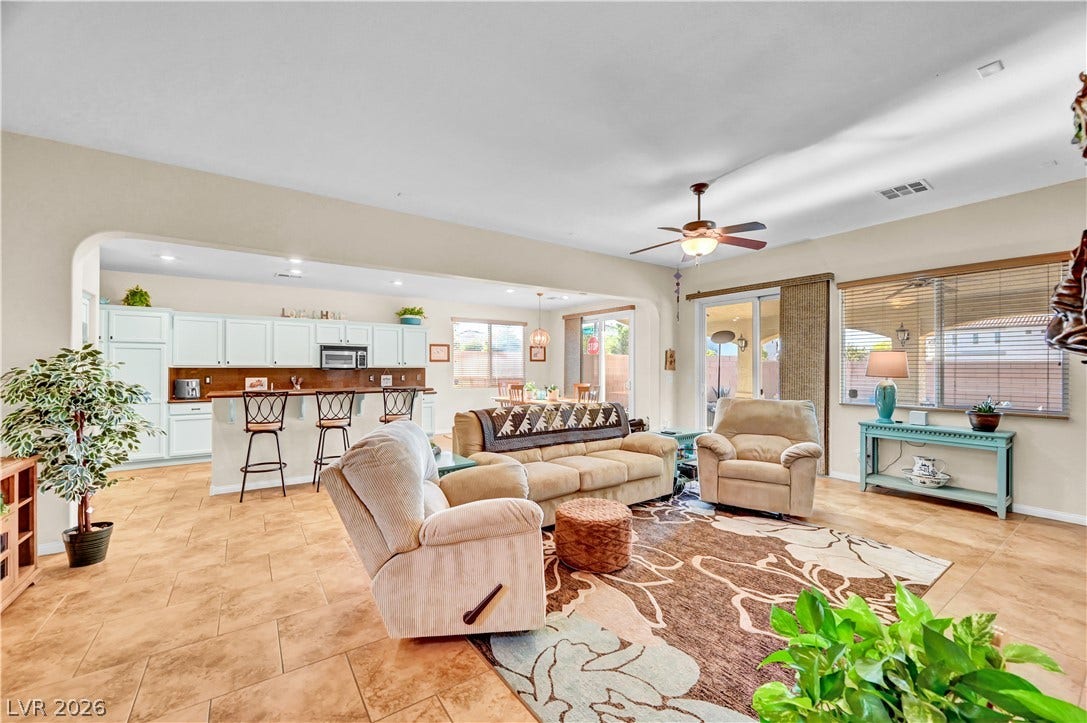 9928 Tradition Creek Avenue, Las Vegas, NV 89149 An inviting open-concept living area boasts warm tile flooring and seamless flow into a well-appointed kitchen.