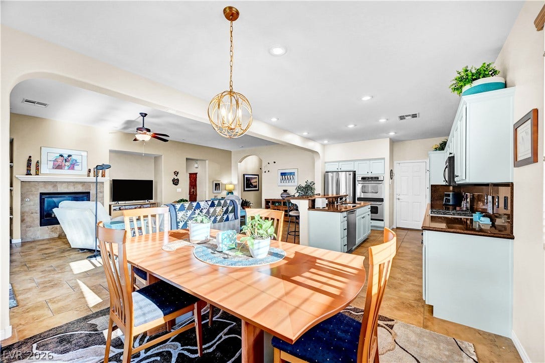 9928 Tradition Creek Avenue, Las Vegas, NV 89149 An open-concept living space integrates a dining area, kitchen, and living room under recessed lighting and elegant fixtures.