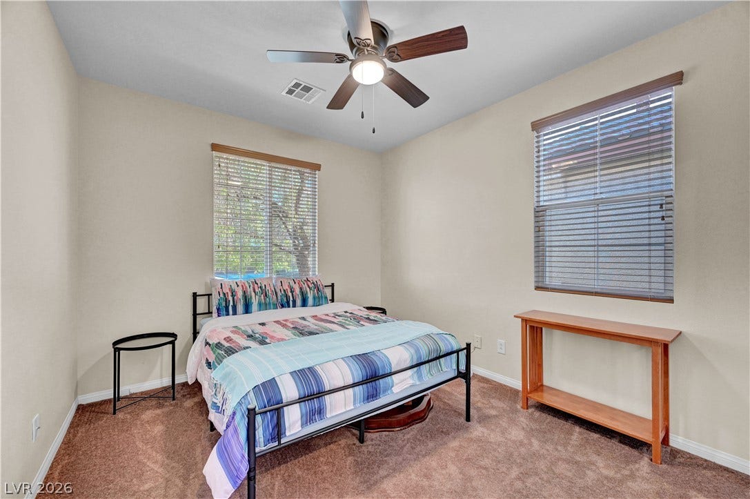 9928 Tradition Creek Avenue, Las Vegas, NV 89149 A comfortable bedroom with a ceiling fan offers a cozy retreat with ample natural light.