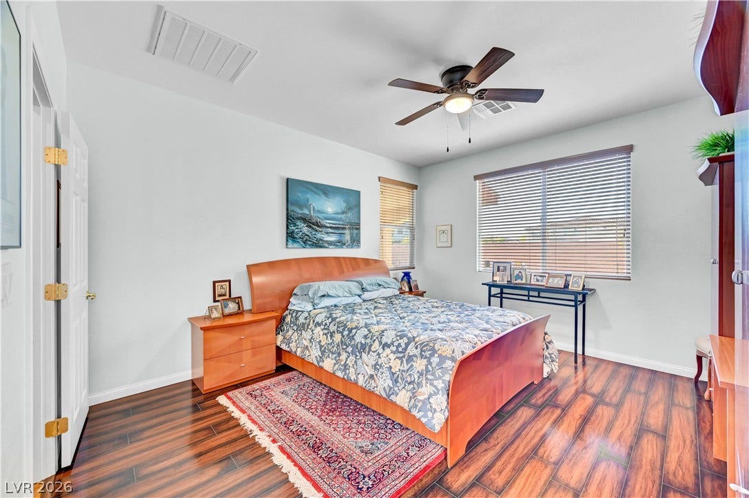 9928 Tradition Creek Avenue, Las Vegas, NV 89149 Hardwood floors and a ceiling fan create a comfortable atmosphere in this well-appointed bedroom.