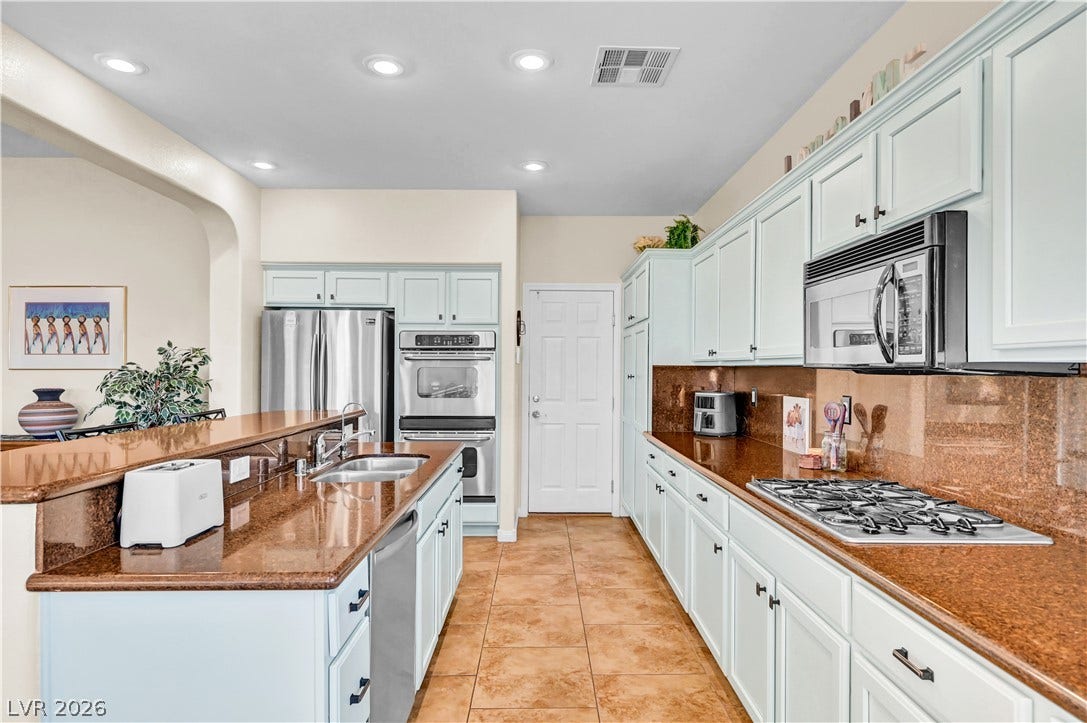 9928 Tradition Creek Avenue, Las Vegas, NV 89149 Culinary creations come to life in this kitchen, featuring ample countertop space and a functional layout.