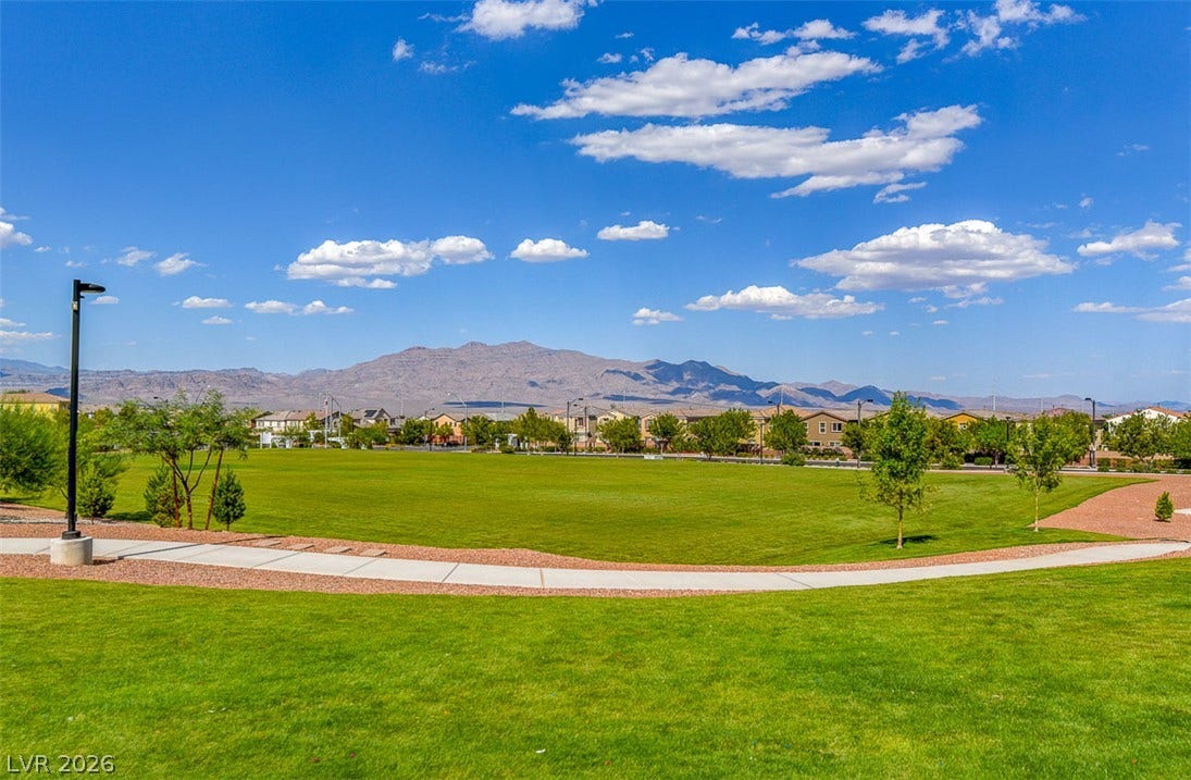 9928 Tradition Creek Avenue, Las Vegas, NV 89149 Green fields and pathways invite outdoor recreation, framed by mountain views and a residential backdrop.