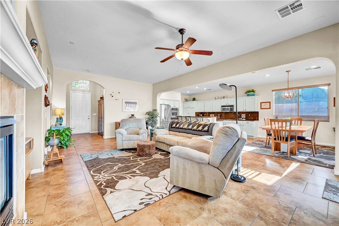 9928 Tradition Creek Avenue, Las Vegas, NV 89149 An inviting open-concept living area boasts a fireplace and flows seamlessly into a well-appointed kitchen and dining space.