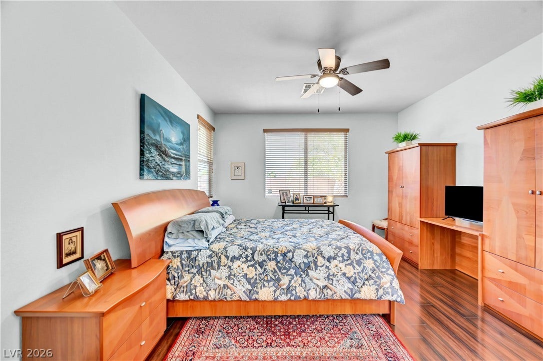 9928 Tradition Creek Avenue, Las Vegas, NV 89149 Hardwood floors and a ceiling fan create a comfortable atmosphere in this well-appointed bedroom.