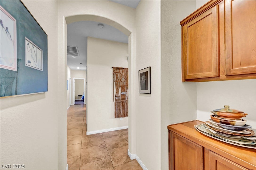 9928 Tradition Creek Avenue, Las Vegas, NV 89149 An inviting archway reveals a hallway with tile flooring, leading to a distant room.